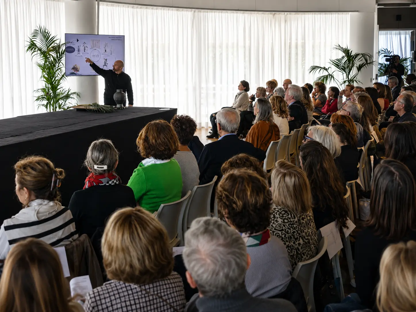 Marco Di Marco durante una conferenza sull'ikebana al Monaco Yacht Club, con il pubblico in sala